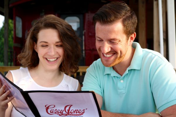 young couple reading restaurant menu together at table
